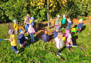 przedszkolaki sprzątają ogród z liści