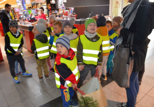 Dzieci czekają z torbami pełnymi zakupów 