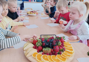 poczęstunek urodzinowy- dzieci jedzą owoce