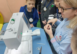 Dzieci interesują się działaniem maszyny do haftowania