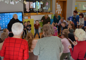 seniorzy i dzieci uczestniczą w zabawie ruchowej