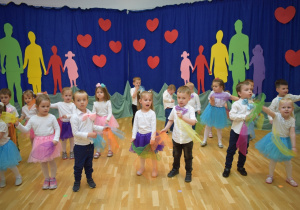 trzy latki tańczą z kolorowymi chustkami