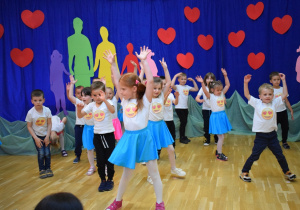dzieci tańczą unosząc ręce do góry
