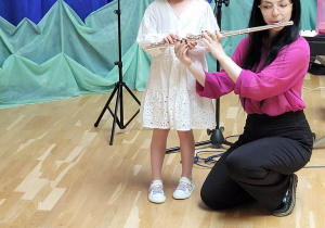 dziewczynka próbuje grać na flecie