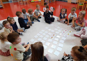 Dzieci odkrywają karty na dywanie