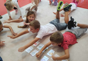 dzieci ćwiczą zgodnie z instrukcja na kartce