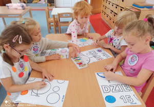 dzieci kolorują części plakatów