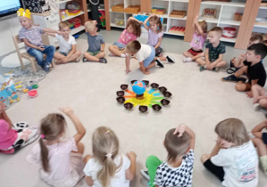 przedszkolaki siedzą na dywanie