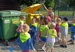 dzieci wrzucają śmieci do kosza