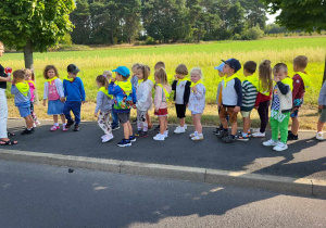 przedszkolaki idą parami na chodniku