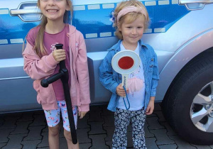 dziewczynki trzymają akcesoria policyjne