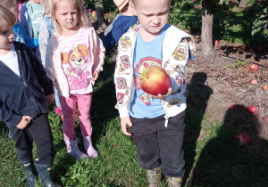 chłopiec pokazuje znalezione jabłko