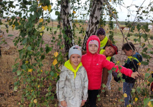 dziewczynki stoją koło drzewa