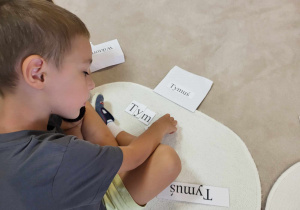 chłopiec układa z literek swoje imię