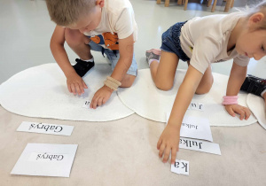 dziewczynka z chłopcem układają z liter swoje imiona