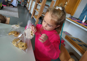 dziewczynka pakuje ciasteczka dla pracowników przedszkola