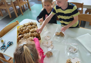 dzieci pakują ciasteczka dla pracowników przedszkola
