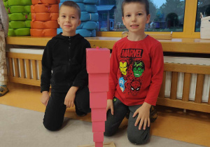 dziecko układa różowa wieżę