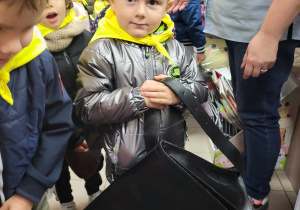 chłopiec trzyma torbę listonosza