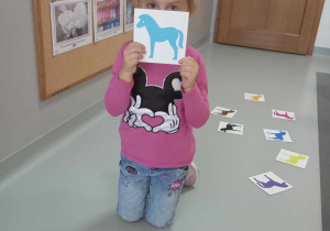dziewczynka trzyma kartę ze zwierzątkiem