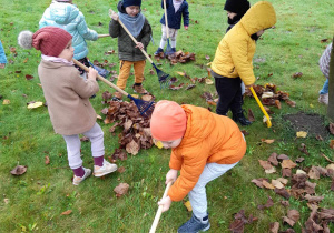 Dzieci pracują przy sprzątaniu liści