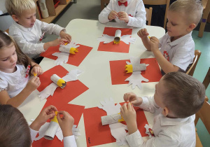 przedszkolaki wykonują pracę plastyczną godło Polski