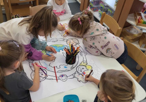 dziewczynki kolorują plakat dotyczący praw dziecka