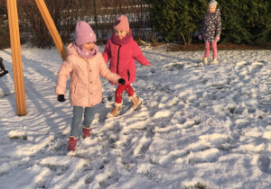 dzieci bawia się na śniegu