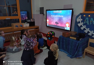 dzieci oglądają filmik o Andrzejkach