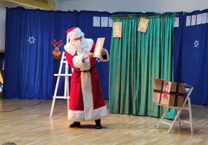 Mikołaj pokazuje obrazek namalowany przez dziecko
