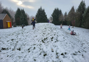 dzieci bawią się na górce ze śniegiem