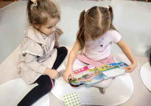dziewczynki oglądają książeczkę