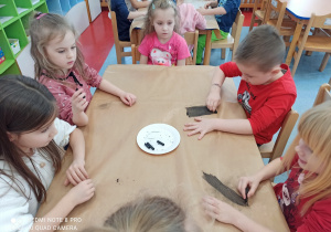 dzieci malują węglem
