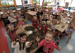 dzieci pokazują ręce ubrudzone węglem