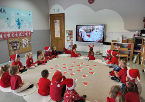 dzieci słuchają listu , który czyta święty Mikołaj