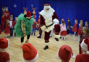 dzieci tańczą z Mikołajem i Choinką