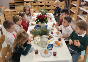 przedszkolaki siedzą przy stole