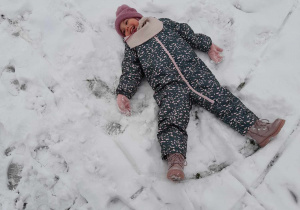 Dziewczynka robi aniołka na śniegu