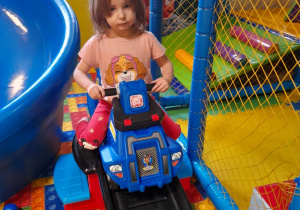 Dziewczynka zjeżdża autkiem
