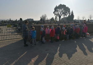 Dzieci stoja przed cmentarzem