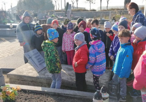 Dzieci stoja wokół grobu 