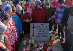 Dzieci stoja wokół grobu 1