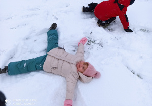 dziewczynka robi aniołka na śniegu