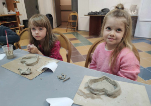 dziewczynki pokazują swoje prace