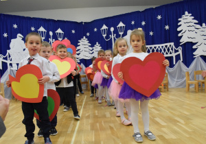 przedszkolaki trzymają papierowe serca w dłoniach