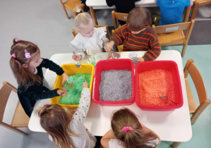 dzieci wybierają odpowiednie kolory soli z misek
