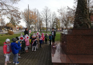Dzieci stoją pod pomnikiem 