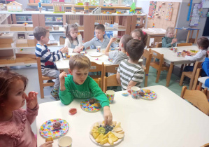 przedszkolaki jedzą owoce i babeczki