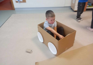 chłopiec bawi się samochodem z pudełka