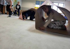 dzieci bawią się w zabawy ruchowe z wykorzystaniem kartonów